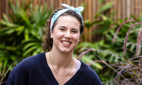 Saskia, a young person impacted by cancer wearing a Canteen bandanna and smiling