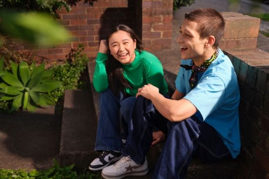two young people sitting and laughing with each other